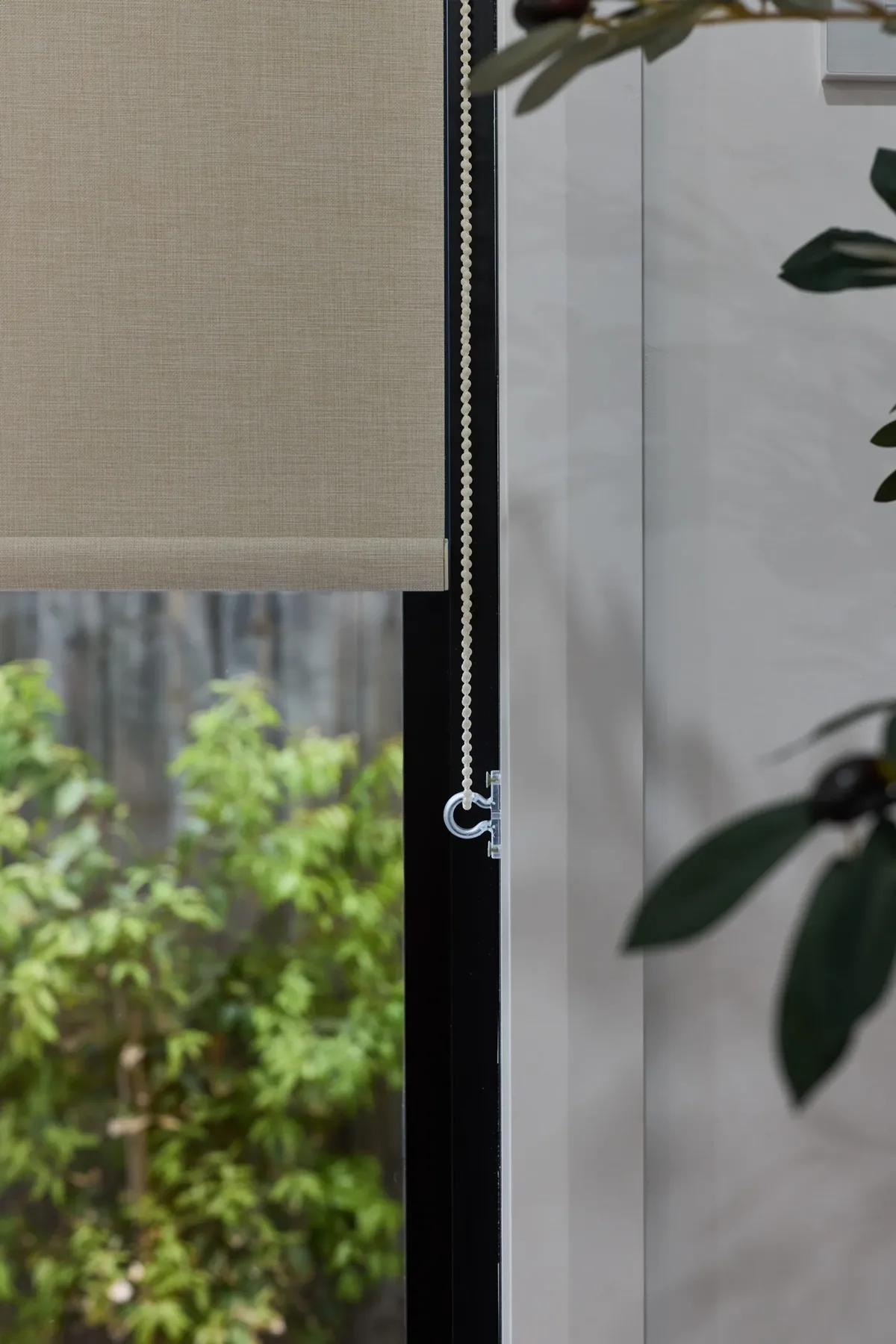 Roller blind lowered beside a glazed door onto the garden