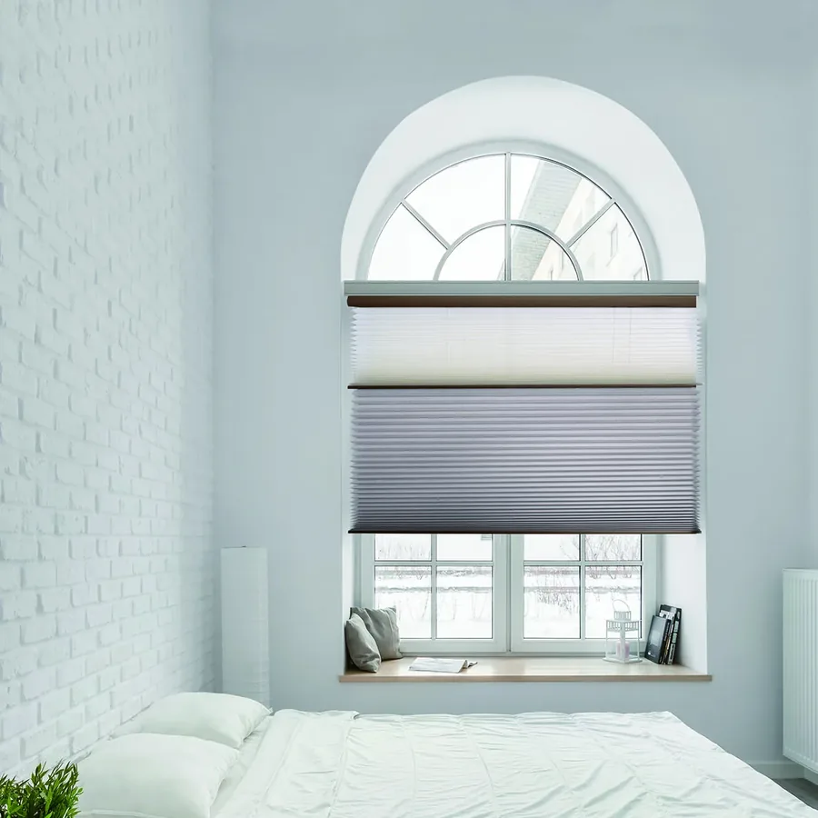 Dual honeycomb blind fitted under an arched bedroom window