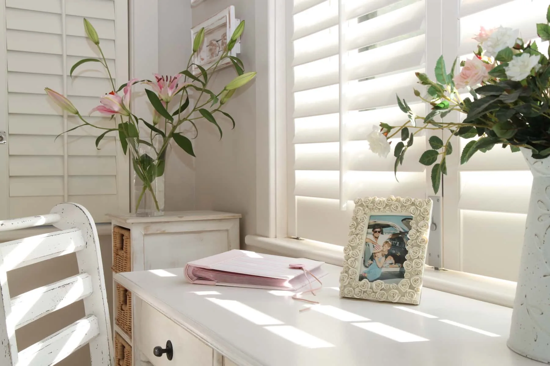 Sunlight falling through plantation shutter louvres above a dresser